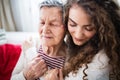 A teenage girl with grandmother at home, hugging. Royalty Free Stock Photo