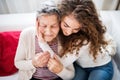 A teenage girl with grandmother at home, hugging. Royalty Free Stock Photo