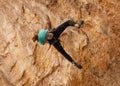 A teenage girl grips the ridges of the limestone formation known as the Cathedral cave in Southern Utah while rock climbing Royalty Free Stock Photo