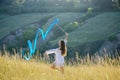 A teenage girl with a gymnastic ribbon on a hillside Royalty Free Stock Photo