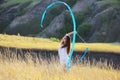 A teenage girl with a gymnastic ribbon on a hillside Royalty Free Stock Photo