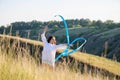 A teenage girl with a gymnastic ribbon on a hillside Royalty Free Stock Photo