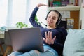 Teenage girl in headphones having fun looking at laptop, at home Royalty Free Stock Photo