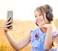 Teenage girl with headphones taking cute selfie