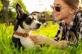 Teenage girl with her cute dog resting on green grass in park Royalty Free Stock Photo