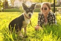 Teenage girl with her cute dog resting on green grass in park Royalty Free Stock Photo