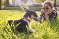 Teenage girl with her cute dog resting on green grass in park Royalty Free Stock Photo