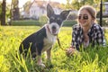 Teenage girl with her cute dog resting on green grass in park Royalty Free Stock Photo