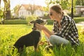 Teenage girl with her cute dog resting on green grass in park Royalty Free Stock Photo