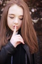 Teenage girl with her finger to her lips for silence Royalty Free Stock Photo