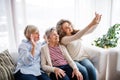 A teenage girl, mother and grandmother with smartphone at home. Royalty Free Stock Photo