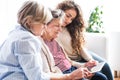 A teenage girl, mother and grandmother with tablet at home. Royalty Free Stock Photo
