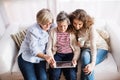 A teenage girl, mother and grandmother with tablet at home. Royalty Free Stock Photo