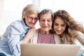 A teenage girl, mother and grandmother with tablet at home. Royalty Free Stock Photo