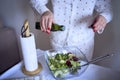 a teenage girl and her mother in pajamas are cooking and eating a fresh green and tomato salad together Royalty Free Stock Photo