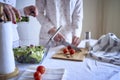 a teenage girl and her mother in pajamas are cooking and eating a fresh green and tomato salad together Royalty Free Stock Photo