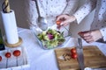 a teenage girl and her mother in pajamas are cooking and eating a fresh green and tomato salad together Royalty Free Stock Photo