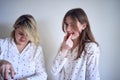 a teenage girl and her mother in pajamas are cooking and eating a fresh green and tomato salad together Royalty Free Stock Photo