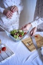 a teenage girl and her mother in pajamas are cooking and eating a fresh green and tomato salad together Royalty Free Stock Photo