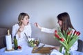 a teenage girl and her mother in pajamas are cooking and eating a fresh green and tomato salad together Royalty Free Stock Photo