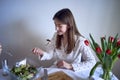 a teenage girl and her mother in pajamas are cooking and eating a fresh green and tomato salad together Royalty Free Stock Photo