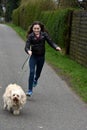 Teenage girl and her sweet little tiver dog running Royalty Free Stock Photo