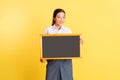 teenage girl in high school uniform holding black chalkboard Royalty Free Stock Photo