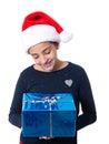 Teenage girl holding a Christmas present and wearing a Santa hat Royalty Free Stock Photo