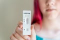 Teenage girl holding Covid-19 rapid antigen test cassette with negative result of rapid diagnostic test