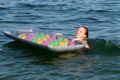 Teenage girl holding an inflatable mattress in the water and laughing Royalty Free Stock Photo