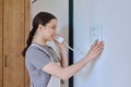 Teenage girl holding intercom handset while talking to guest