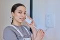 Teenage girl holding intercom handset while talking to guest