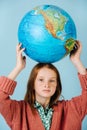 Teenage girl holding planet earth globe on her head Royalty Free Stock Photo