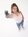 Teenage girl holding up cellular phone and smiling