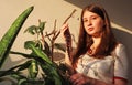 A teenage girl holds a braid cut from her hair