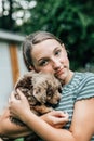 Teenage girl holds and snuggles with new labradoodle puppies