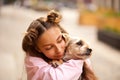 Teenage girl hugging little pet dog in a park outdoor Royalty Free Stock Photo