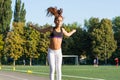 A teenage girl jumping rope in a school stadium.