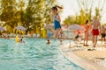 Teenage girl jumps into the water from the side of the pool Royalty Free Stock Photo