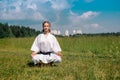 Teenage girl karateka before starting training outdoor enters the mokuso meditative state in the seiza pose