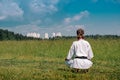 Teenage girl karateka before starting training outdoor enters the mokuso meditative state in the seiza pose