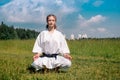 Teenage girl karateka before starting training outdoor enters the mokuso meditative state in the seiza pose