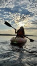 teenage girl is kayaking at sunset in Pacific Ocean, only the silhouette of Kayak Paddles is visible she swims along Royalty Free Stock Photo