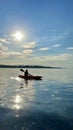 teenage girl is kayaking at sunset in Pacific Ocean, only the silhouette of Kayak Paddles is visible she swims along Royalty Free Stock Photo