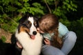 teenage girl kiss australian shepherd dog in summer. in forest Royalty Free Stock Photo