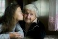 A teenage girl kisses her great-grandmother. Royalty Free Stock Photo