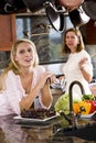 Teenage girl in kitchen chatting with mother Royalty Free Stock Photo