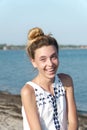 A teenage girl laughs contagiously against the backdrop of the sea coast. Royalty Free Stock Photo