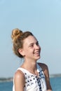 A teenage girl laughs contagiously against the backdrop of the sea coast. Royalty Free Stock Photo