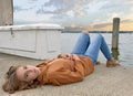 Teenage girl laying marina dock